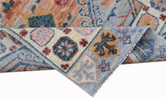 A handwoven transitional Oushak runner featuring a floral pattern in soft, multi-colored wool.