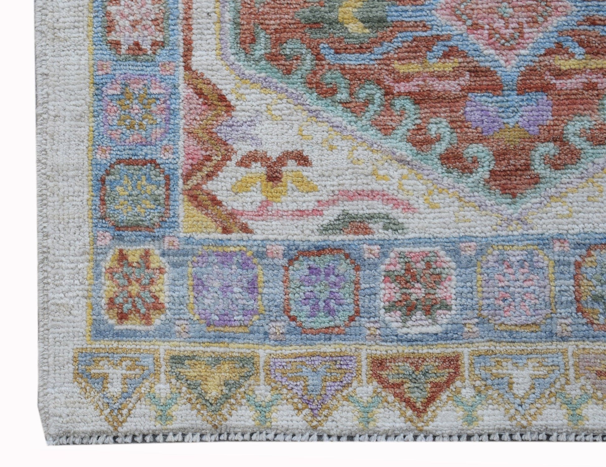 A handwoven transitional Oushak runner featuring a floral pattern in soft, multi-colored tones.