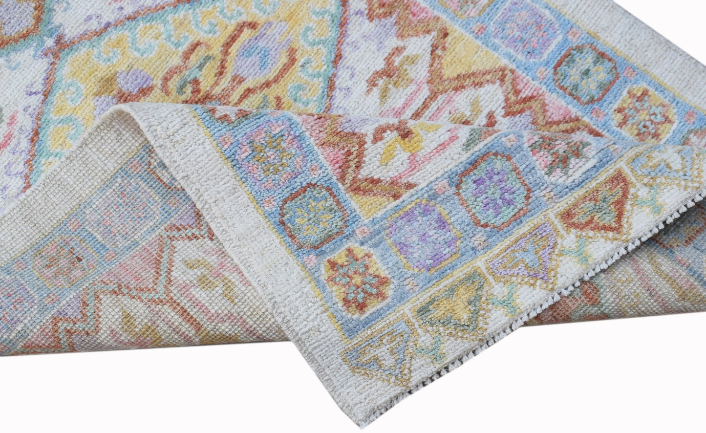 A handwoven wool runner rug featuring a transitional Oushak pattern in soft pastel colors.