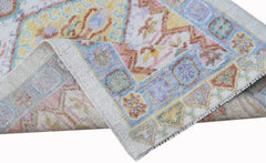 A handwoven wool runner rug featuring a transitional Oushak pattern in soft pastel colors.