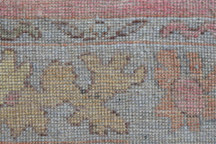 A close-up view of a handwoven wool runner featuring a faded floral pattern in soft pastel tones.