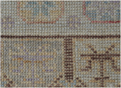 A close-up of a handmade wool runner rug featuring a traditional pattern in muted earth tones.