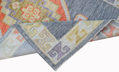 A handwoven transitional Oushak runner featuring a geometric pattern in blue, orange, and yellow.