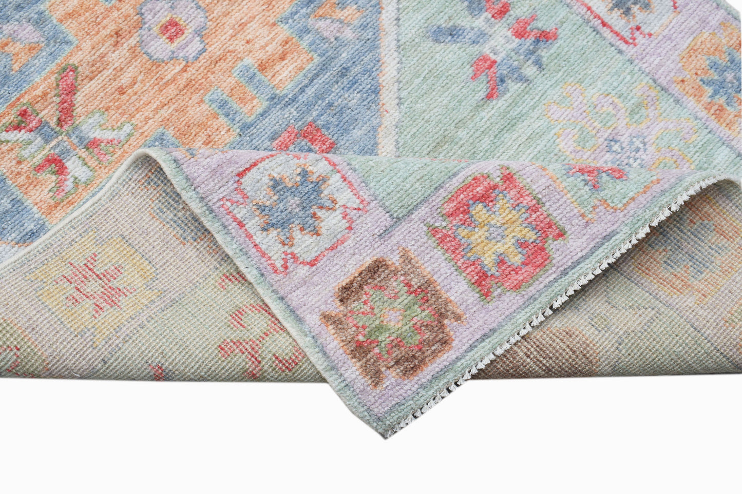 A handwoven transitional Oushak runner featuring a colorful floral pattern on wool.