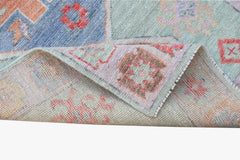 A handwoven transitional Oushak runner featuring a floral pattern in soft blue and pastel tones.