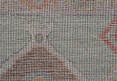 A close-up view of a handwoven wool runner featuring a transitional Oushak pattern in muted tones.