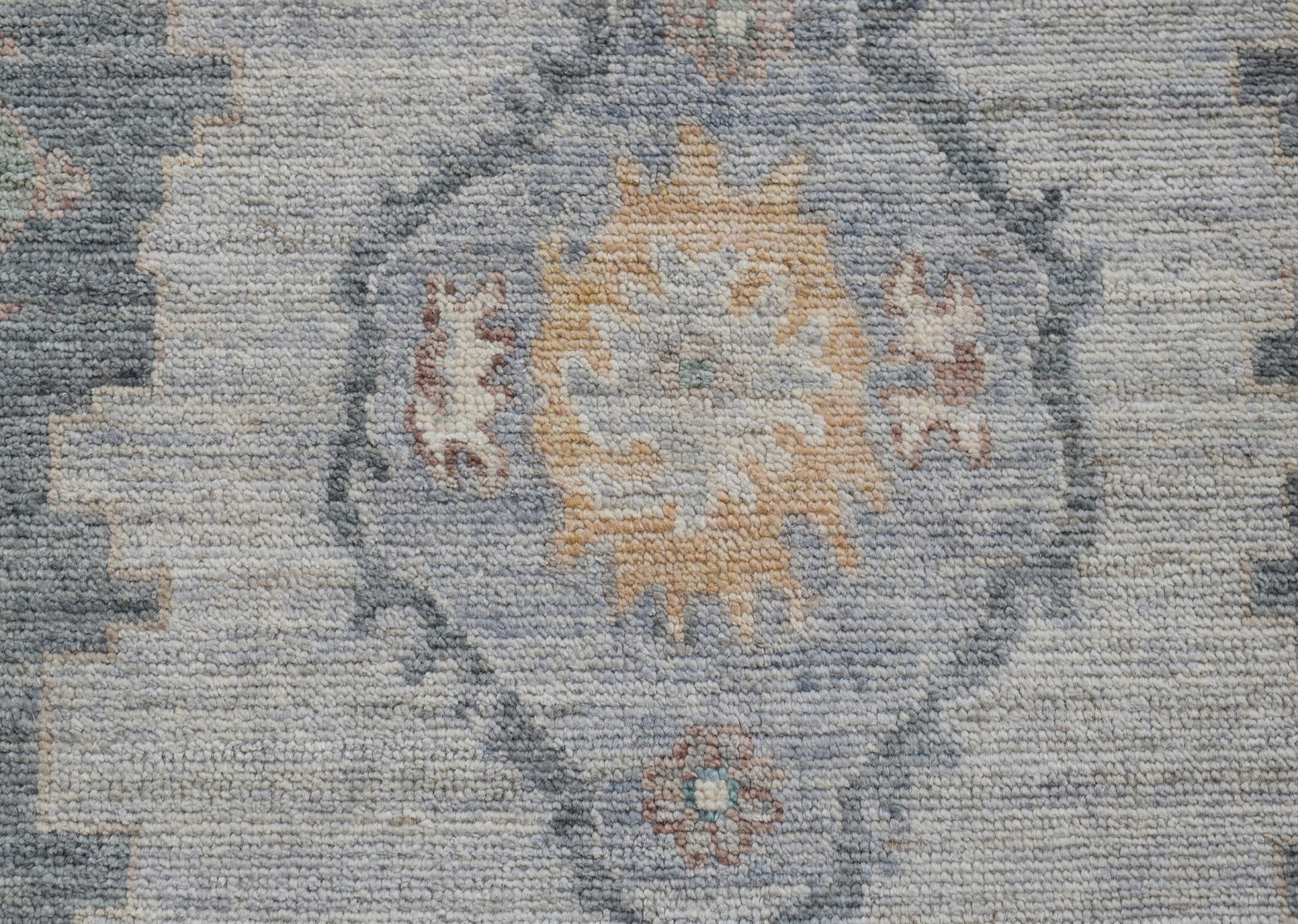 A handwoven wool runner featuring a transitional Oushak floral pattern in soft blue and tan tones.