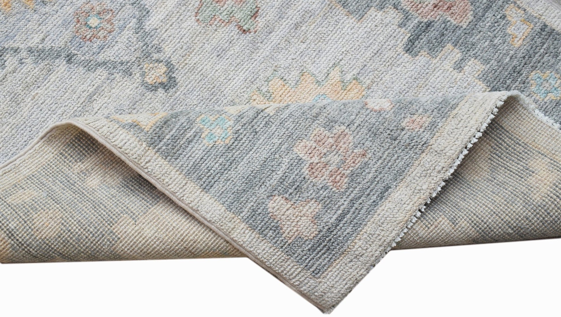 A handwoven transitional Oushak runner featuring a floral pattern in soft blue and neutral tones.