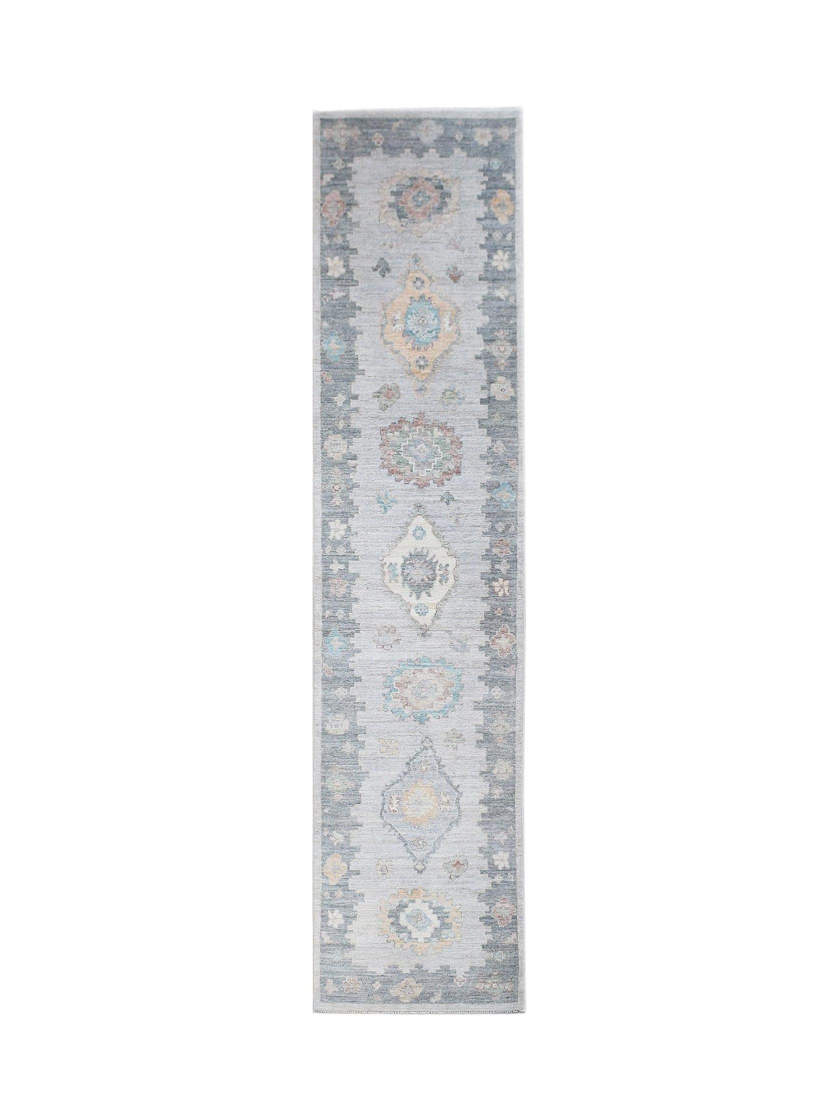 A handwoven transitional Oushak runner rug featuring a light blue field with floral motifs.