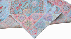 A handwoven transitional Oushak runner featuring a floral pattern in blue, pink, and purple tones.