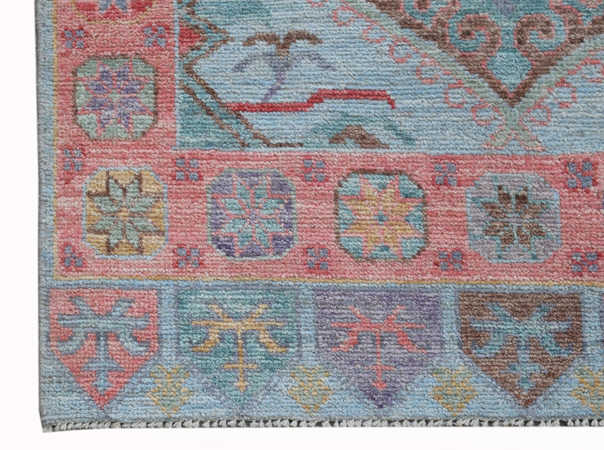A handwoven transitional Oushak runner featuring a geometric floral pattern in soft pastel tones.