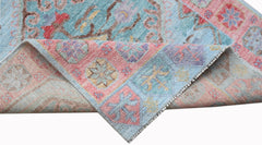 A handwoven wool runner with a floral pattern in shades of blue, pink, and yellow.