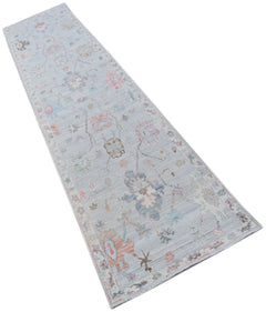 A handmade Afghan Oushak runner rug featuring a traditional floral pattern in soft pastel tones.