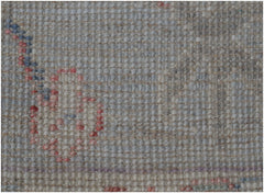 A close-up view of a handmade wool runner rug featuring a traditional pattern in soft muted tones.