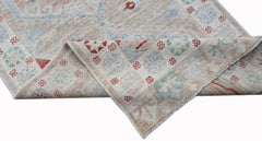 A handwoven transitional Oushak runner featuring a floral pattern in muted tones on wool.