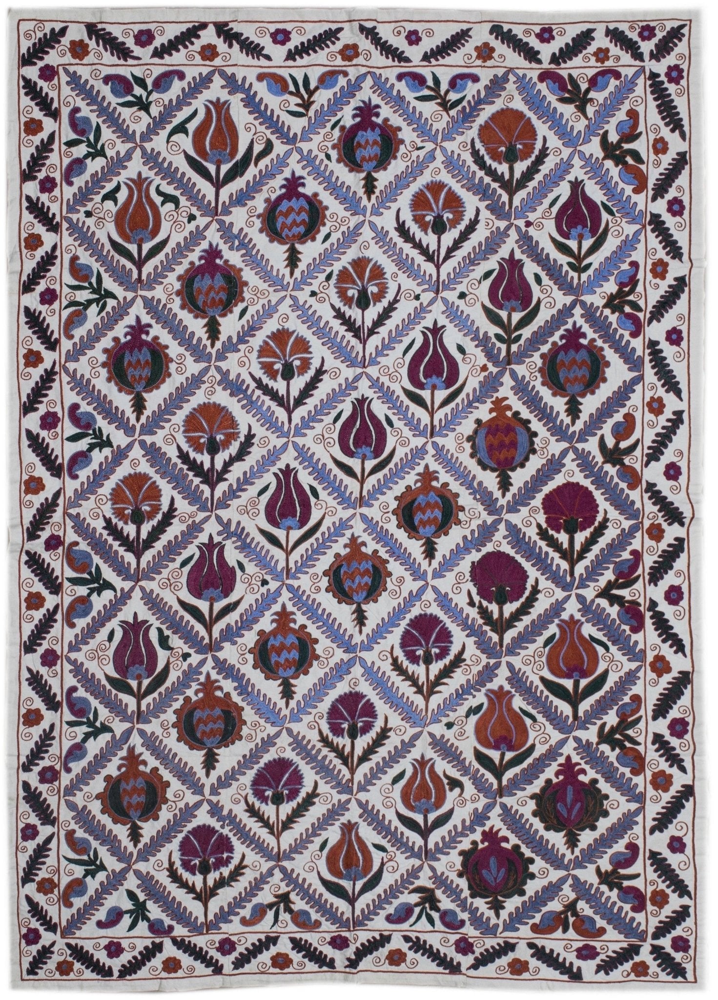 Hand-embroidered Uzbek Suzani featuring a diamond lattice pattern of floral and pomegranate motifs.