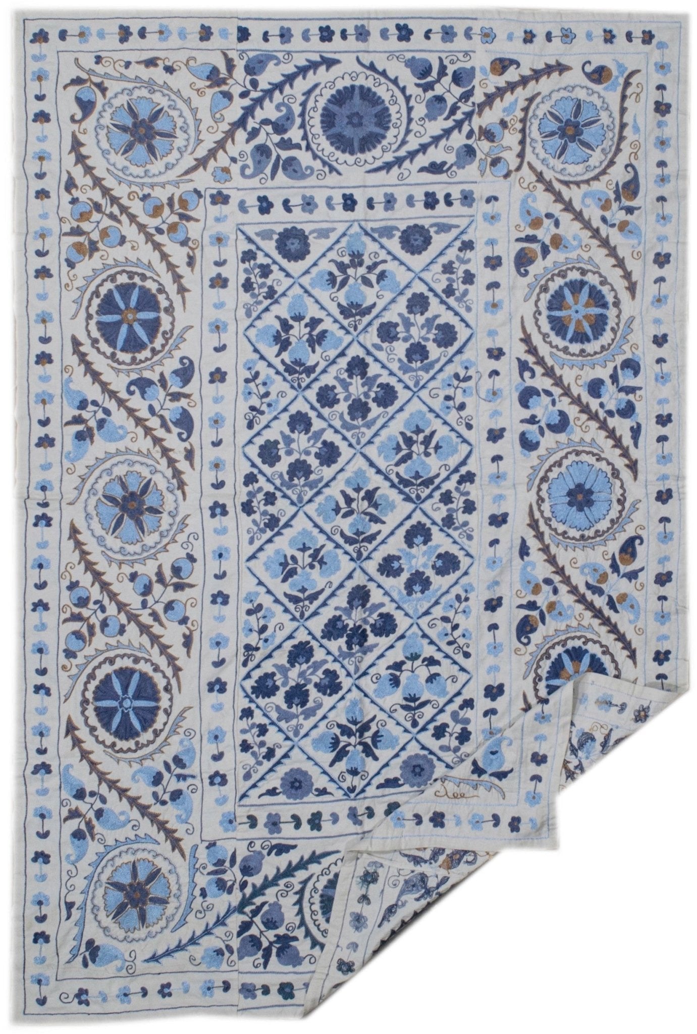 A rectangular Uzbek suzani featuring intricate blue floral embroidery on a light cotton background.
