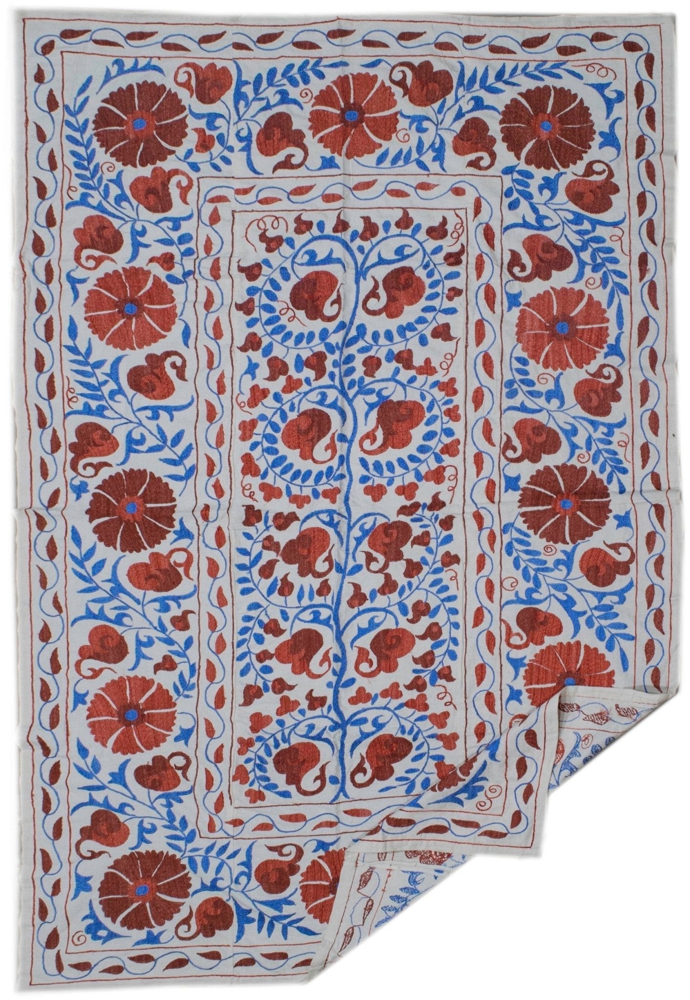 Hand-embroidered Uzbek suzani featuring red floral motifs and blue vines on a white cotton base.