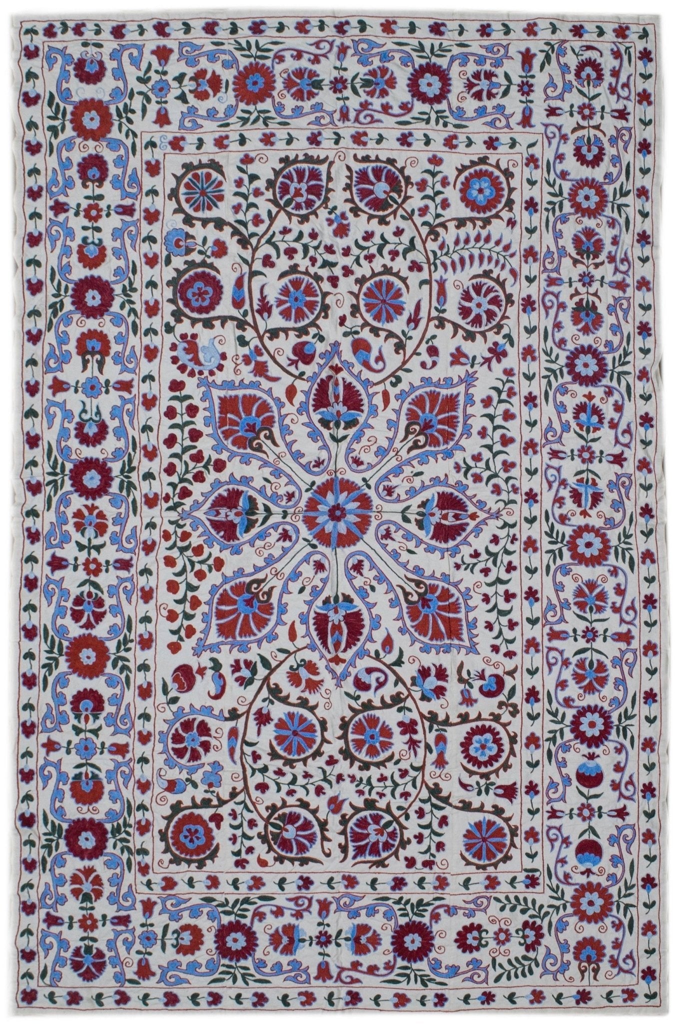 Hand-embroidered Uzbek suzani featuring intricate floral and vine motifs in red and blue silk.
