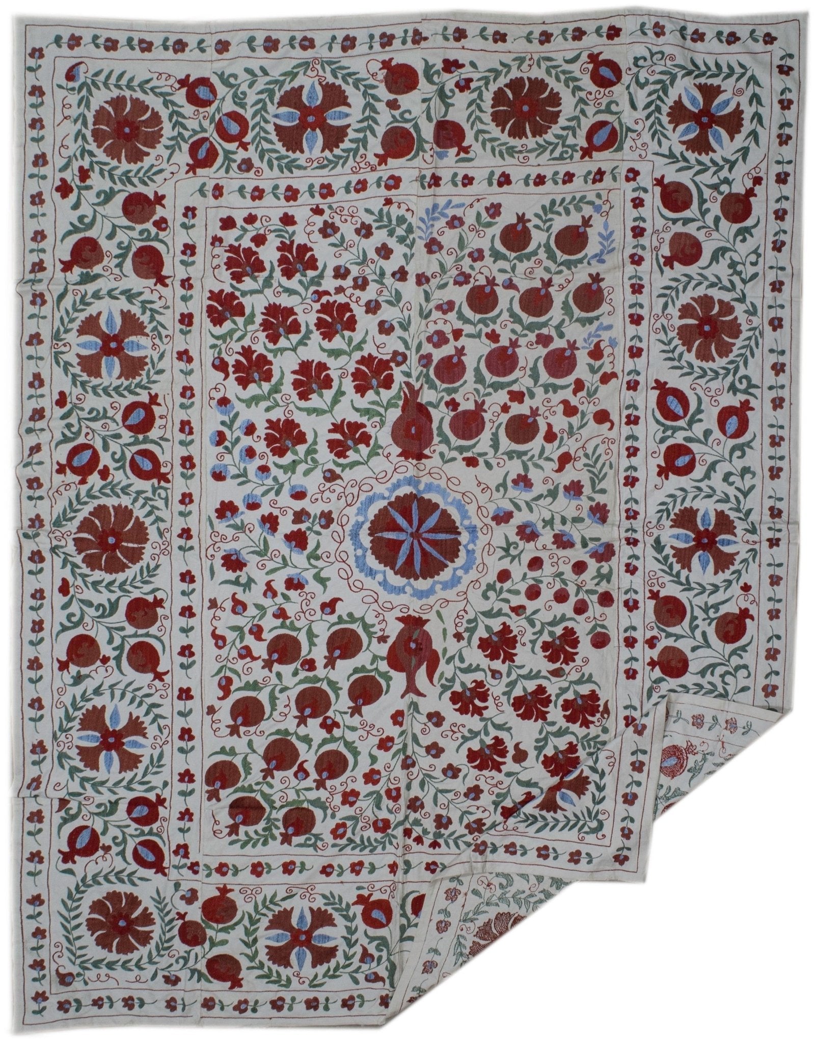 Handmade Uzbek suzani textile featuring intricate floral and pomegranate embroidery on cotton.