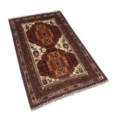 A vintage handmade Afghan Baluch rug featuring geometric patterns in deep red and cream tones.