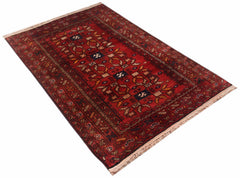 A vintage handwoven Afghan Baluch rug featuring a traditional geometric pattern in deep red tones.