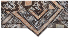A handwoven vintage Afghan Baluch rug featuring geometric patterns in brown, orange, and cream.