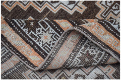 A handwoven vintage Afghan Baluch rug featuring geometric patterns in brown, orange, and cream.