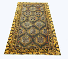A vintage handwoven Afghan Baluch rug featuring geometric motifs in a dark field with yellow borders.