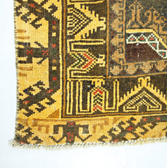 A vintage handwoven Afghan Baluch rug featuring geometric patterns in yellow, brown, and red.