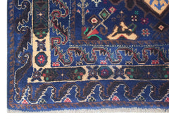 A vintage handmade Afghan Baluch rug featuring intricate geometric patterns in blue and cream.