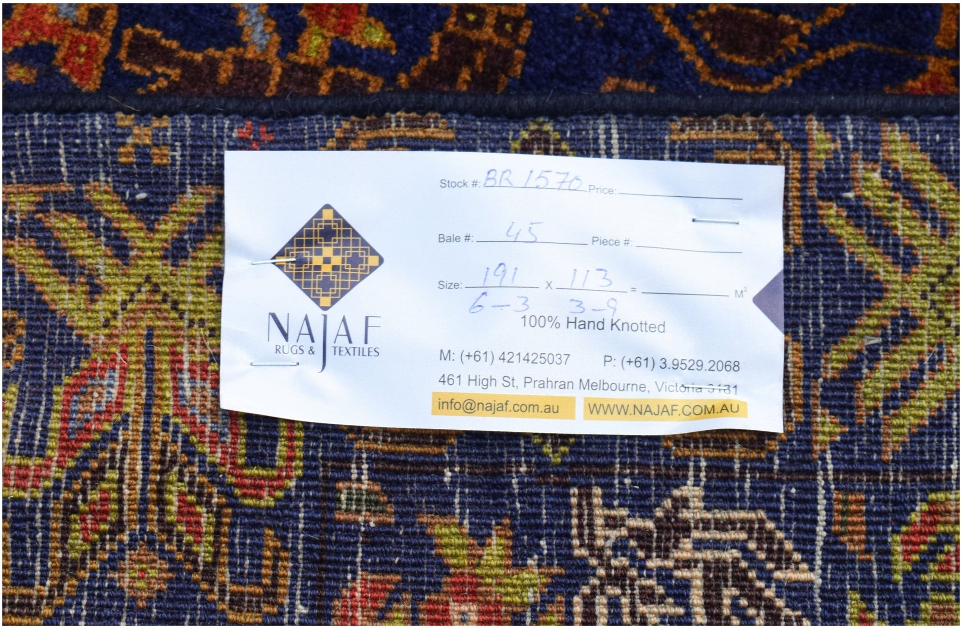 A vintage Afghan Baluch rug featuring intricate patterns in deep blue, red, and gold tones.