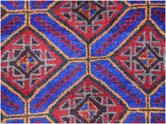 A vintage Afghan Baluch wool rug featuring a geometric pattern of red and blue diamonds.