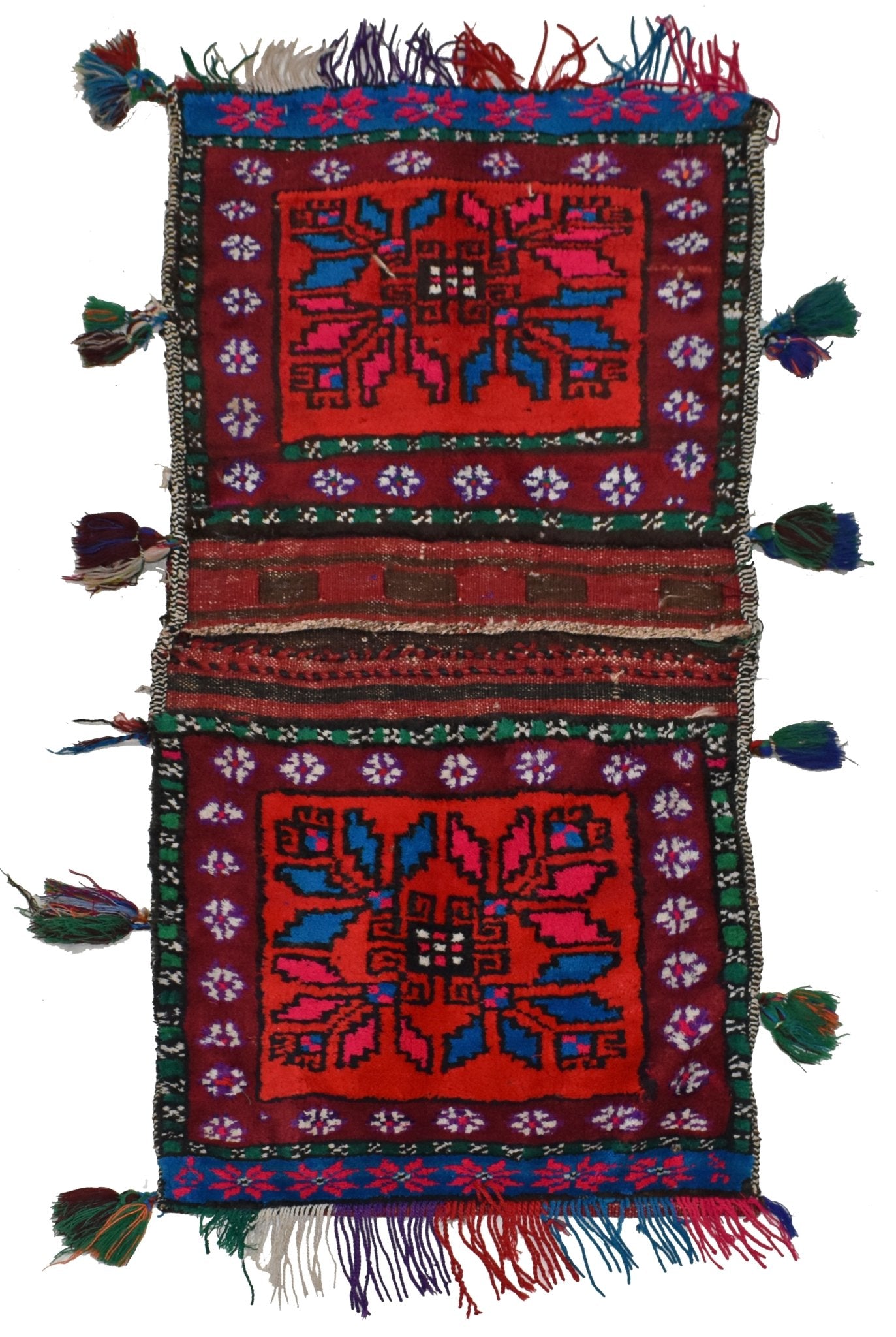 A vintage handmade Afghan wool saddle bag featuring two red panels with geometric floral motifs.