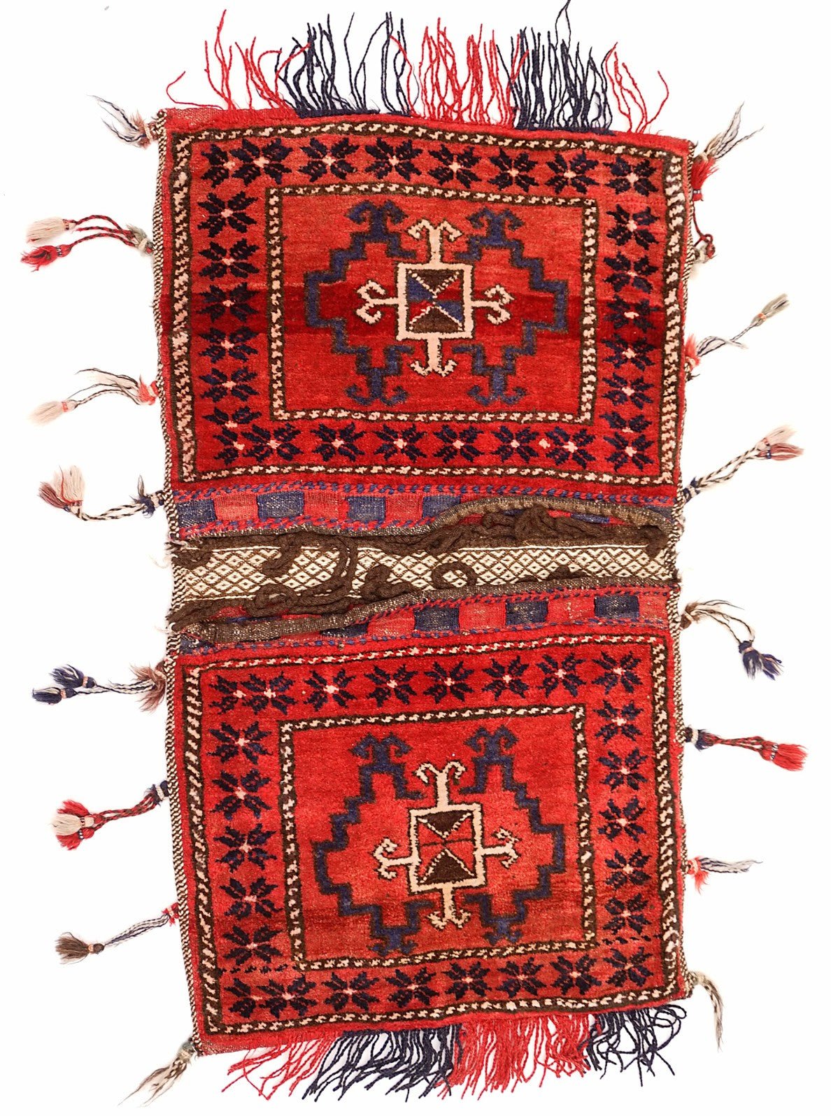 A handmade vintage Afghan wool saddle bag featuring two red panels with geometric tribal motifs.