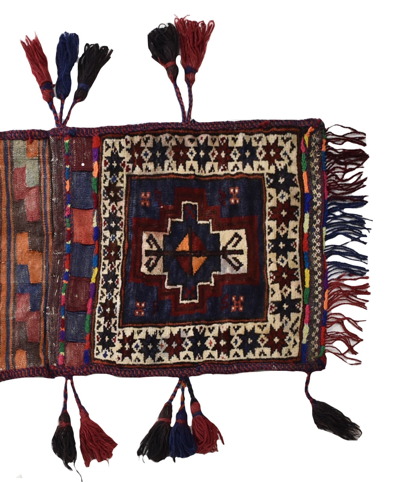 A handmade vintage Afghan wool saddle bag featuring a geometric pattern and decorative tassels.