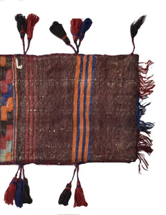 A vintage handmade Afghan wool saddle bag featuring brown fabric with colorful striped accents.