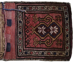 A vintage handmade Afghan wool saddle bag featuring a geometric red and brown tribal pattern.