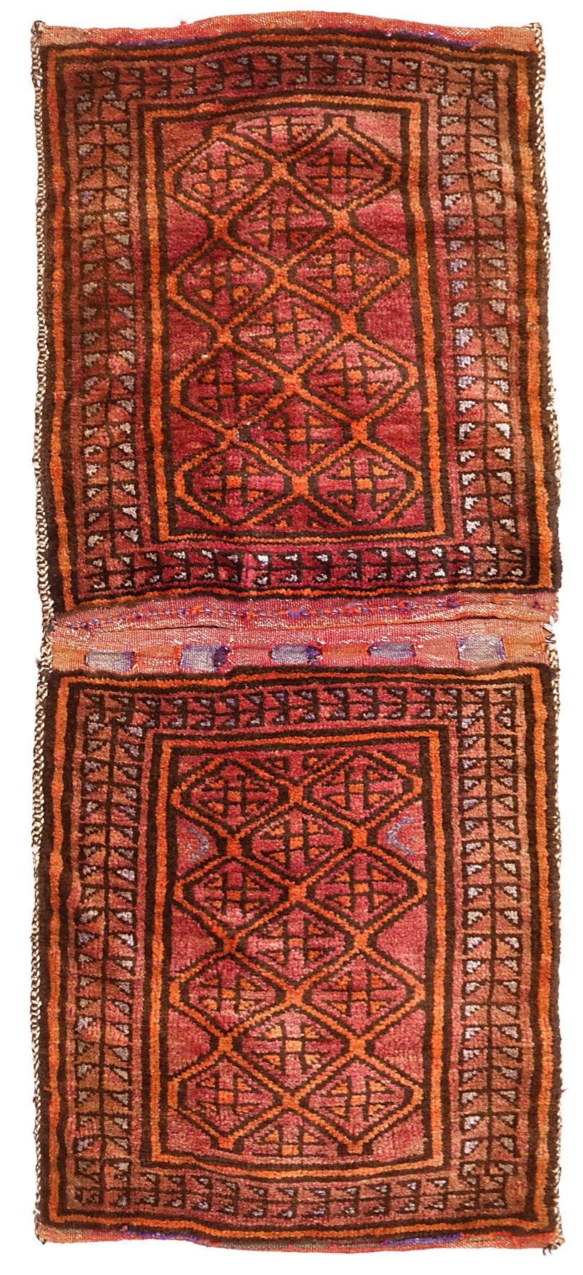 A vintage handmade Afghan wool saddle bag featuring a repeating diamond pattern in red and orange.
