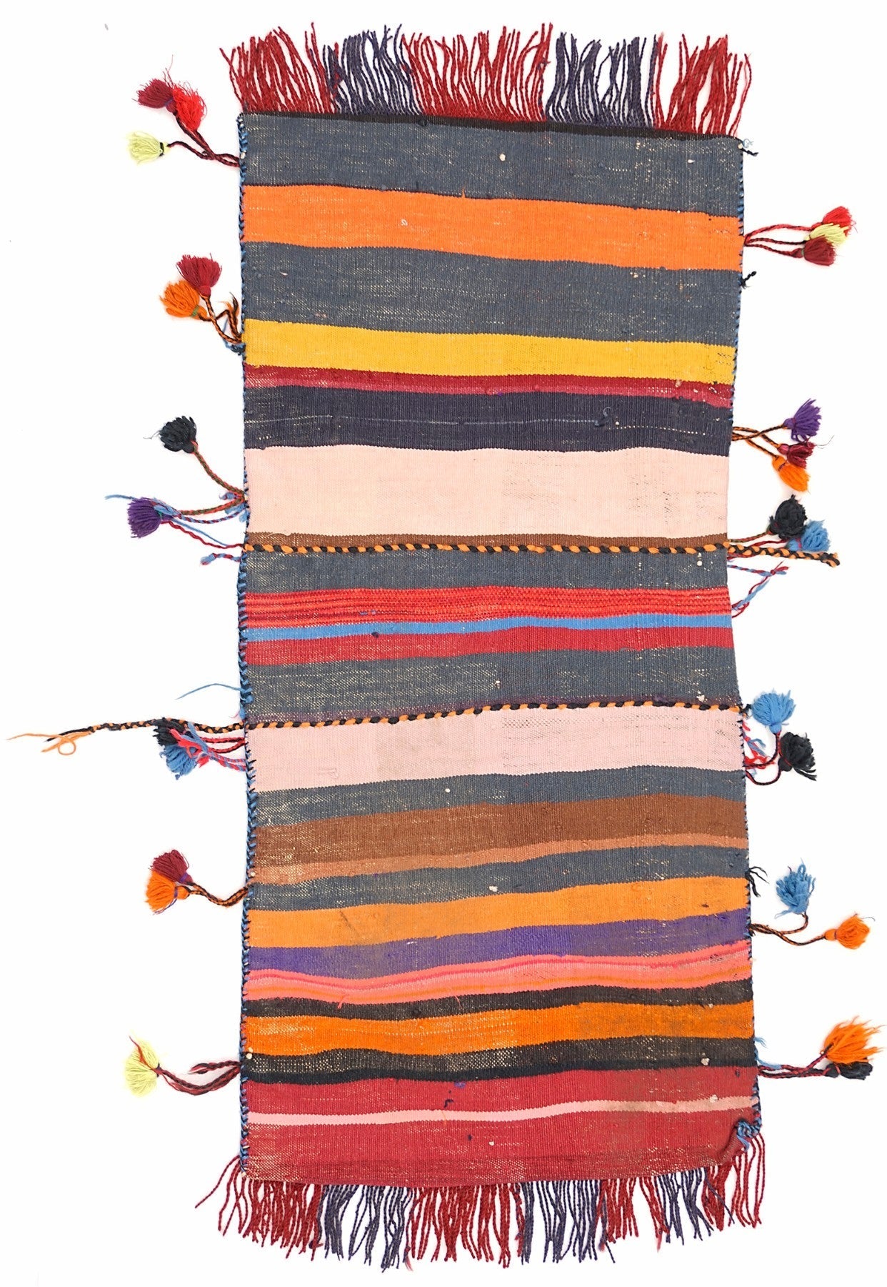 A handmade vintage Afghan wool saddle bag featuring colorful horizontal stripes and side tassels.