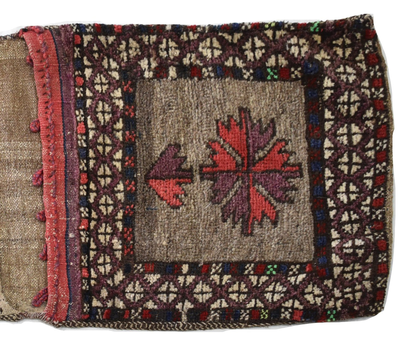 A vintage handmade Afghan wool saddle bag featuring a central floral motif and geometric borders.