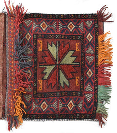 A handmade vintage Afghan wool saddle bag featuring a central floral motif and geometric borders.