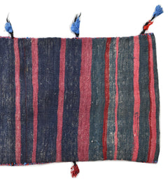 A vintage Afghan wool saddle bag featuring vertical stripes in shades of blue, pink, and red.