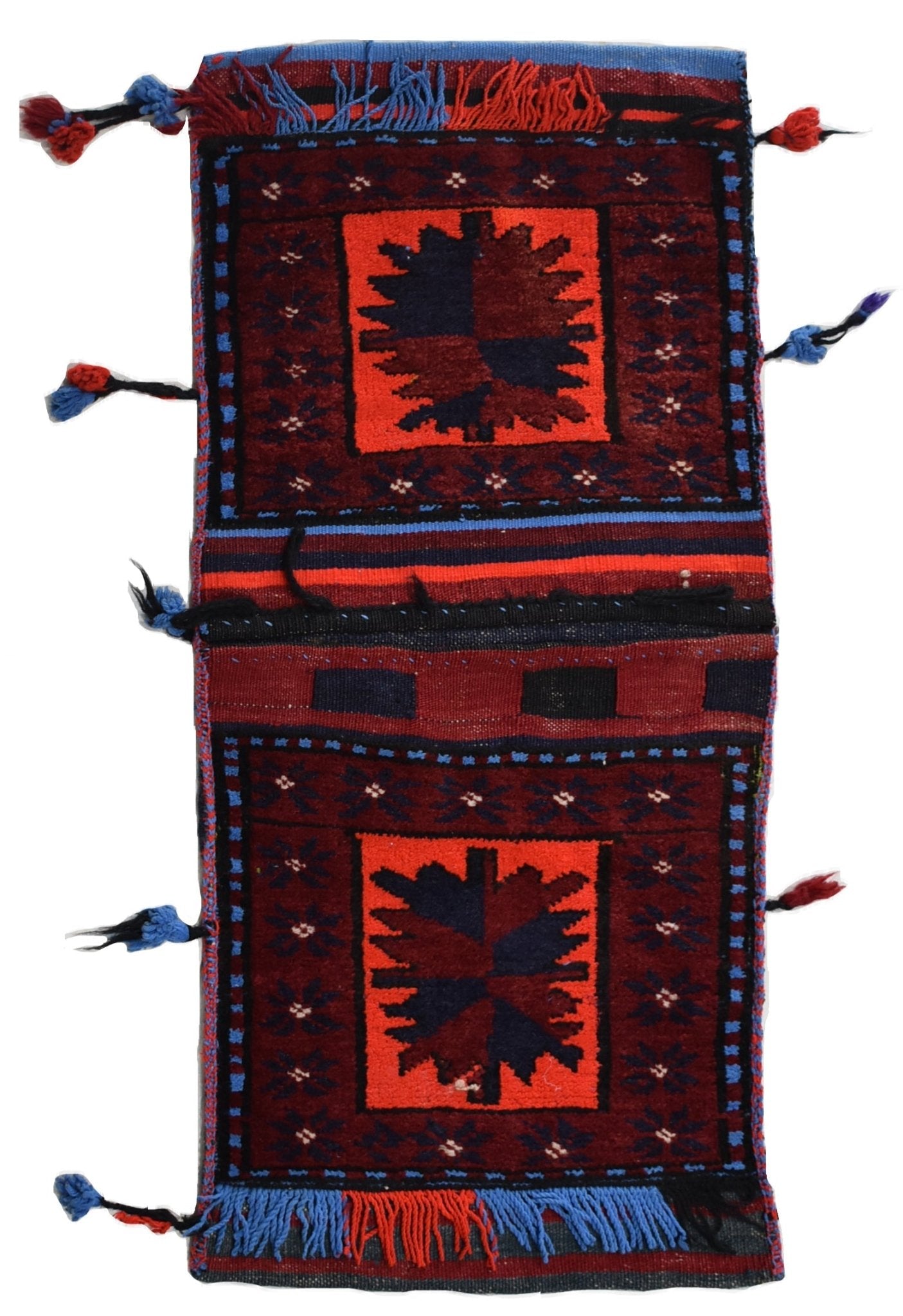 A vintage handmade Afghan wool saddle bag featuring two red panels with dark geometric motifs.
