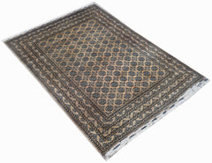 A handmade vintage Afghan Turkmen rug featuring a geometric pattern in tan and dark blue tones.