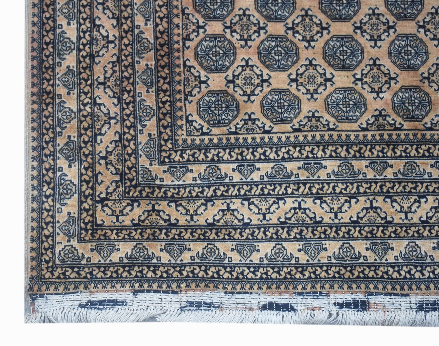 A vintage Afghan Turkmen rug featuring a geometric octagonal pattern in tan and dark blue.