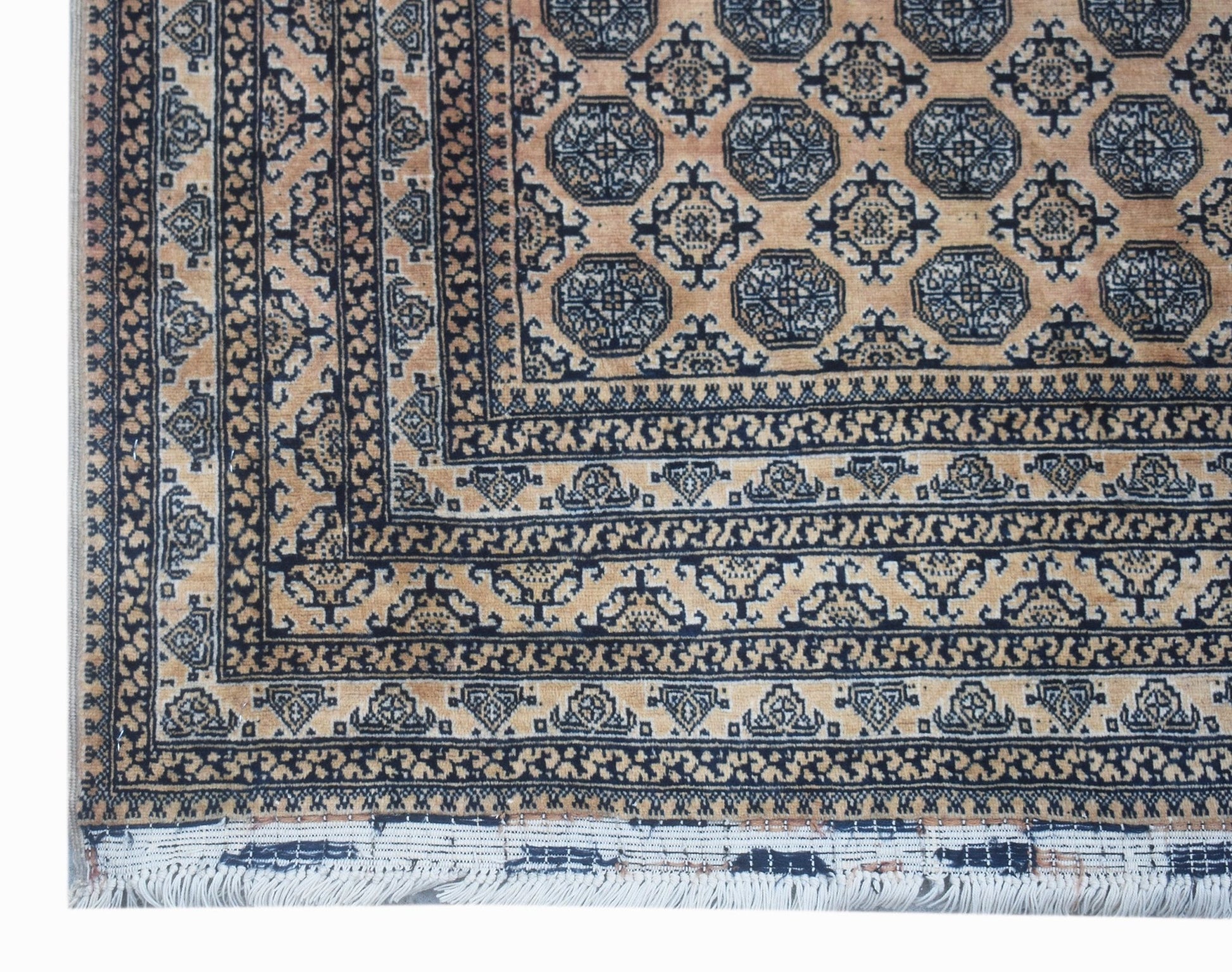 A vintage Afghan Turkmen rug featuring a geometric octagonal pattern in tan and dark blue.