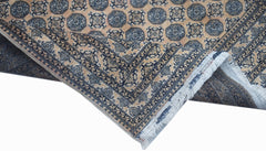 A vintage Afghan Turkmen rug featuring a geometric pattern in blue and tan with a fringed edge.