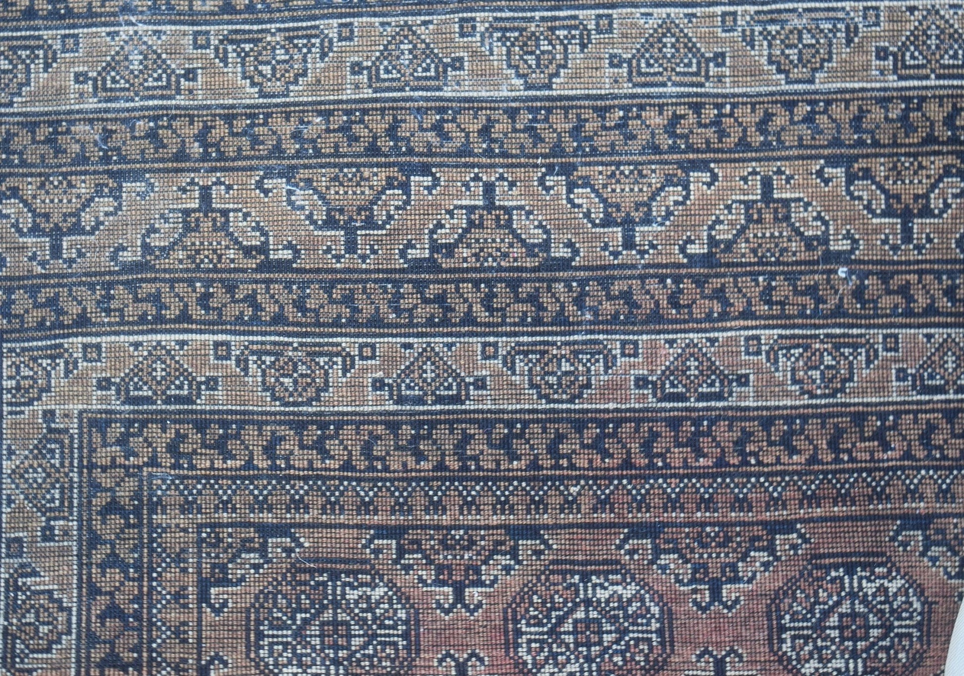 A vintage Afghan Turkmen rug featuring intricate geometric patterns in brown and black wool.