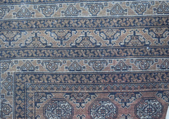 A vintage Afghan Turkmen rug featuring intricate geometric patterns in brown and black wool.